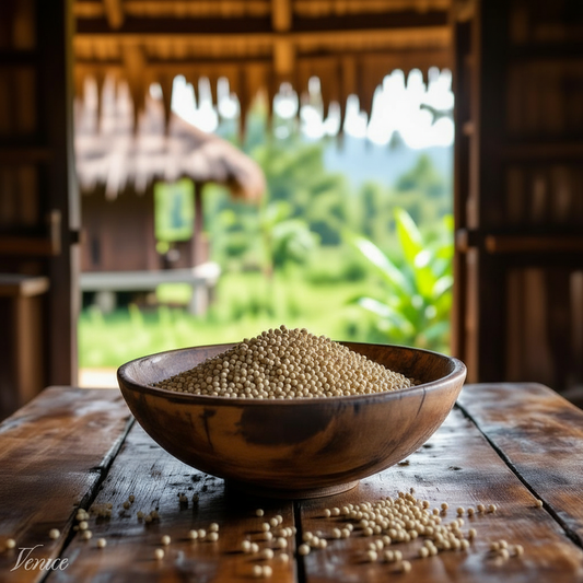 White peppercorns in wooden bowl on rustic table with tropical outdoor view