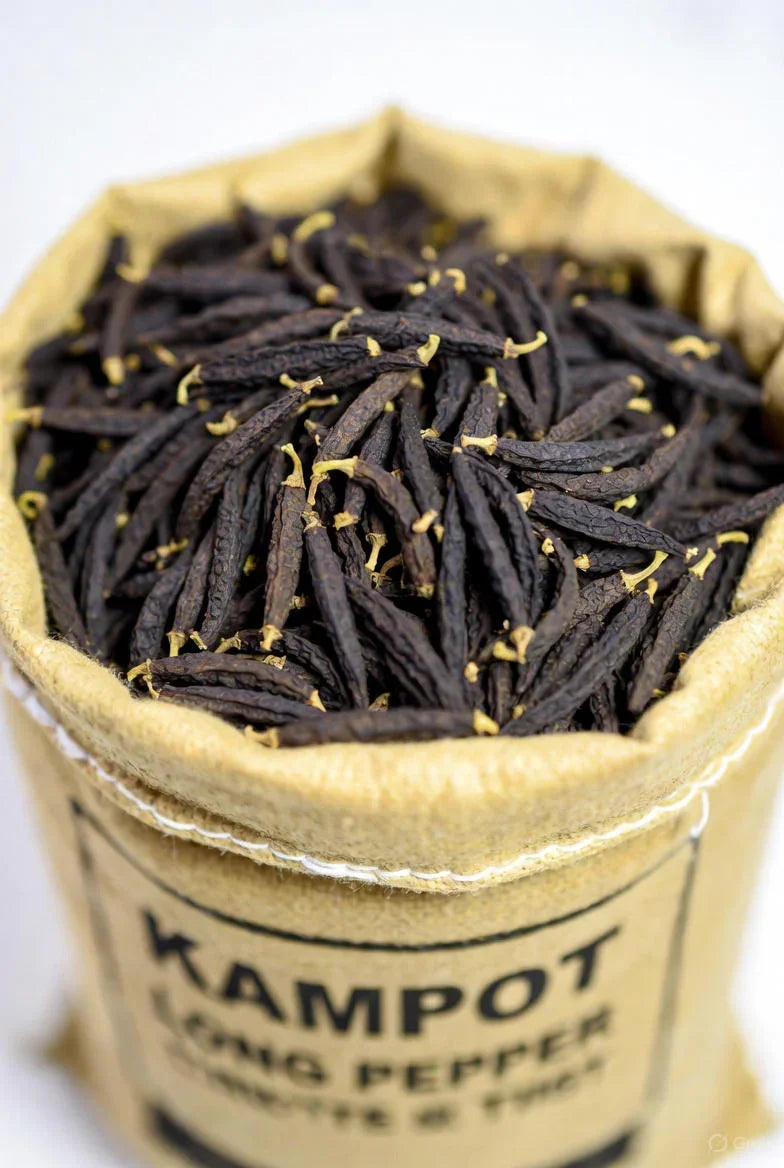 Bag of dried Kampot long pepper with wrinkled texture and yellow stems on white background