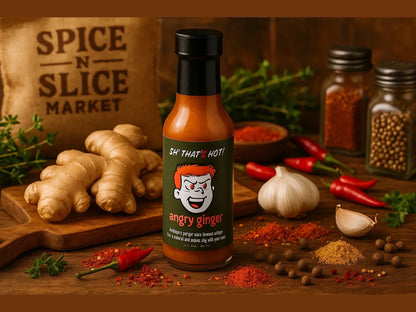 Angry Ginger hot sauce bottle in a market setting with ginger, garlic, spices, and chili peppers