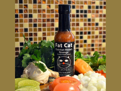 Fat Cat Chairman Meow's Revenge hot sauce bottle with fresh cilantro, garlic, lime, tomato, and onion