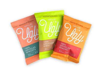 Three Hello I'm Ugly dried fruit snack bags, labeled upcycled apricots, kiwis, and peaches.