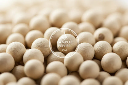 Close-up of beige Kampot peppercorns with PGI label and leaf logo overlay