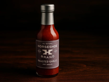 Horseshoe Brand roasted garlic hot sauce bottle on dark wooden surface