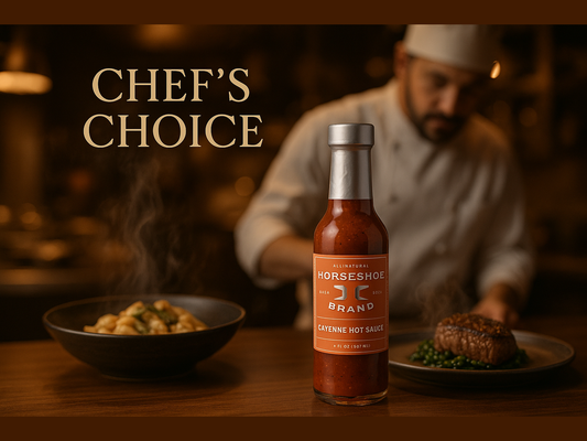 Horseshoe Brand cayenne hot sauce bottle on restaurant table with chef and plated dishes